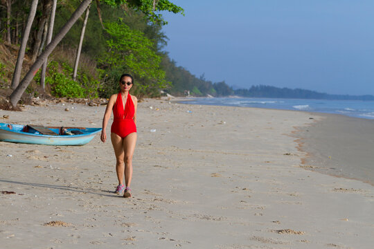 Woman with red swimsuit walk relax on beach