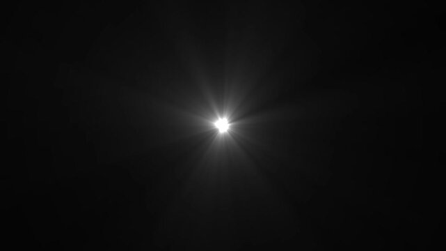 A bright white starburst lens flare emanates from a central point, casting sharp rays of light outwards against a deep black background, creating a dramatic and luminous effect. Keywords: light