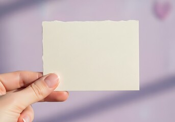Fototapeta premium Person Hand Holding Blank Cream Paper Mockup against Purple Background
