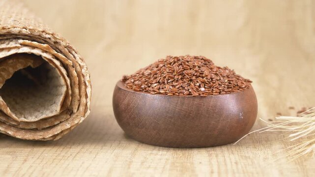 Flax seeds in wooden bowl on kitchen table