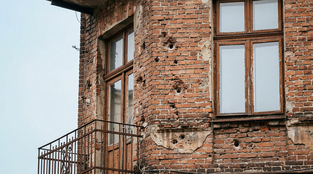 Damaged brick building with bullet holes.