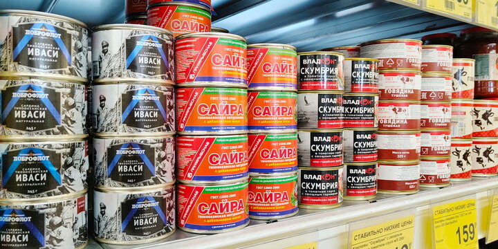 Russia, Samara. February 11, 2025. A variety of canned fish on the shelf of a large store. Text in Russian: Dobroflot, Iwashi, Saira, Mackerel, Beef, Stewed, Pacific, Natural, Consistently Low Prices