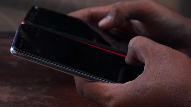 Sync and backup data, Close up of hands holding two smartphones transferring data between devices, mobile file sharing and wireless connection, syncing files, messages and contacts.