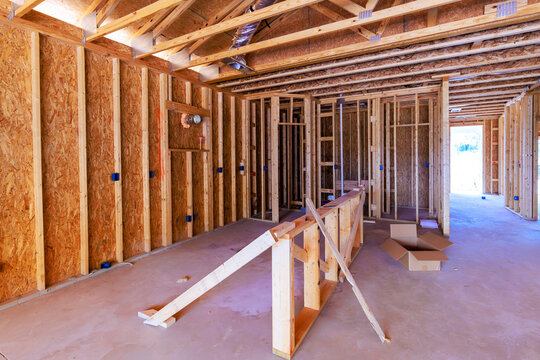 Workers are installing wooden frames in house under construction in residential neighborhood