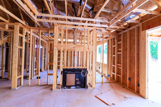 Workers are building new house with wooden framing an area set for fireplace floor is clear empty.