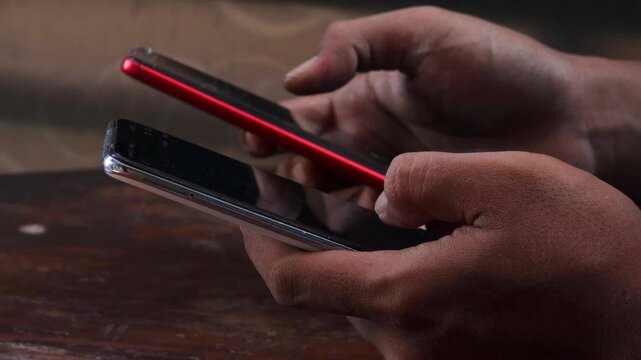 Sync and backup data, Close up of hands holding two smartphones transferring data between devices, mobile file sharing and wireless connection, syncing files, messages and contacts.