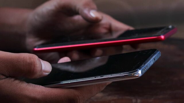 Sync and backup data, Close up of hands holding two smartphones transferring data between devices, mobile file sharing and wireless connection, syncing files, messages and contacts.