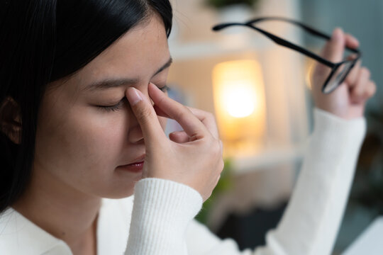 Eye problems, Asian women with tired and irritated eyes, eye rubbing, dry, eye pain after work, migraine, headache, blurred vision, photophobia, working in the dark, blue light from computer