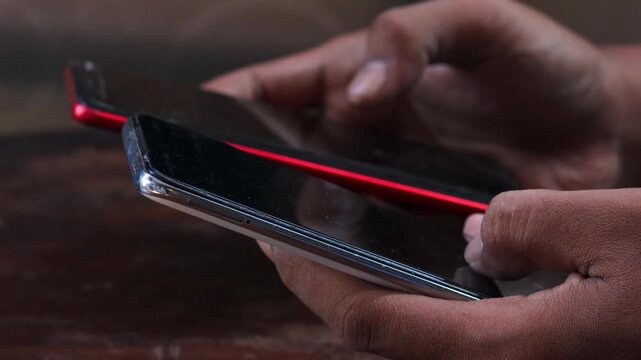 Sync and backup data, Close up of hands holding two smartphones transferring data between devices, mobile file sharing and wireless connection, syncing files, messages and contacts.