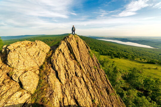 a young handsome man travels through the mountains of the Southern Urals on a summer day