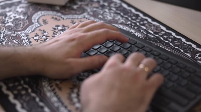 Person Swiftly Inputting Data On Keyboard. Rapid Keystrokes Executed On Patterned Mouse Pad Workspace. Media