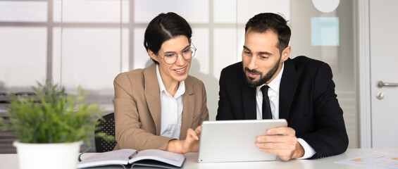 Naklejka premium Colleagues collaborate on strategy, analyzing data, reviewing project details, studying new business platform using digital tablet at meeting in corporate office. Discussion, professional consultation