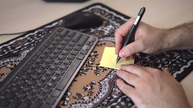 Placing Sticky Note On Desk For Reminders. Casual Task Planning Using Notes Near Computer Keyboard. Media