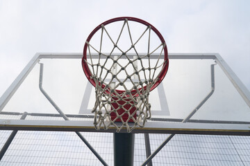 Close-up view of a basketball hoop and net against a bright sky with slam dunk basketball equipment backboard athletic competition recreation challenge activity training practice exercise © Arhamnyx