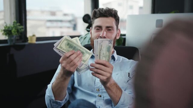 A Confident Man Counting Cash While in a Modern Office Setting, Showcasing Success and Ambition