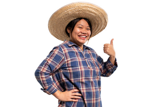 Cheerful young Asian farmer woman giving thumbs up. Happy gardener in blue plaid shirt and straw hat showing like or approval gesture, isolated on transparent background, PNG file format.