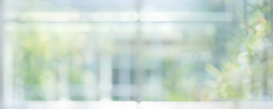 Blurred soft bokeh green nature with reflection of glass wall housing.Bright abstract background for design