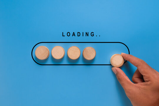 male hand put wooden blocks in loading screen. isolated on blue background. progress concept