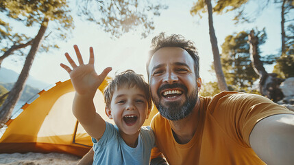 Obraz premium Joyful father and son taking selfie while camping outdoors near yellow tent surrounded by trees and sunlight, sharing happy and playful moment together