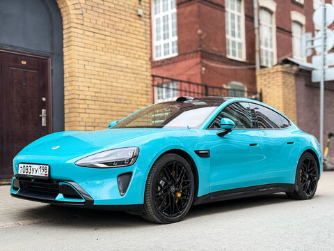Xiaomi SU 7 MAX turquoise color parked at the city street side view. Exterior of a bluenXiaomi SU7 MAX Chinese electric car. A dynamic and intelligent electric car from China. 