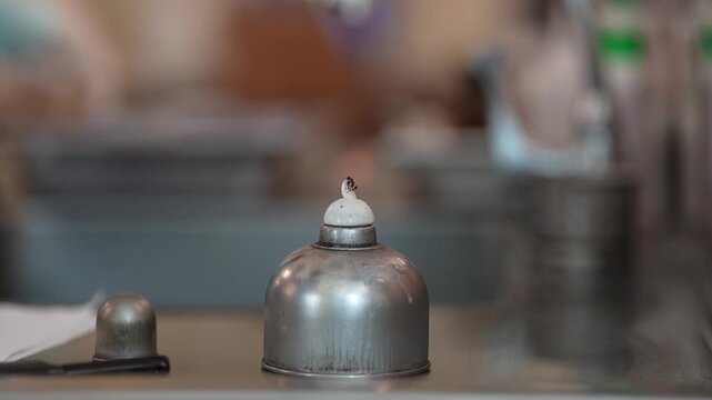 Laboratory alcohol burner metal science equipment chemistry flame source tool close up blurred background laboratory scientific equipment safety glove glass container fuel burner cap dome bench top