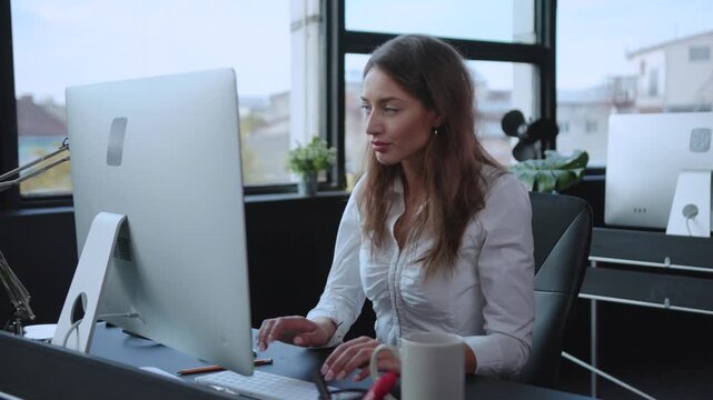 Dedicated and Focused Young Woman Engaged in Work Within a Modern Office Environment