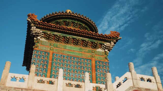 Ornate temple pavilion under blue sky, imperial glazed tiles, colorful bracket sets, carved balustrade, warm sunlight highlighting rafters, traditional craftsmanship, cultural landmark, cinematic