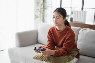 Young Asian woman gamer controller video console playing holding hobby playful Online Video Game enjoyment eSport Cyber Games Internet. © Charlie's