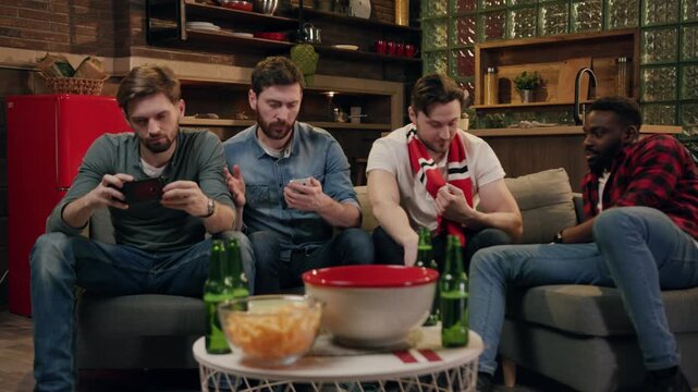 A group of friends joyfully watching a game together in their cozy and inviting living room