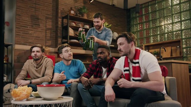 A group of friends happily watching a sports game together on a cozy weekend evening