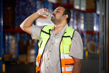 Warehouse worker staying hydrated with a water bottle during a break