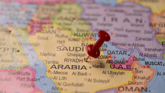 Close-Up World Map Shot Showing Red Pin Highlighting Riyadh Saudi Arabia Pointed by Hand 4K 60fps