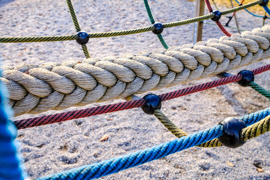 Climbing ropes in a playground structure with bright colors against a clear sky
