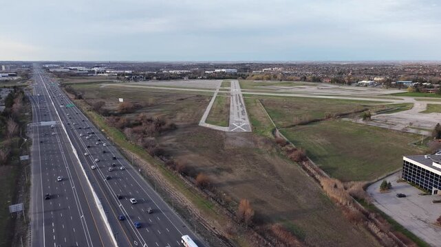 Low-altitude aerial drone footage descending toward and flying over the abandoned runway of the decommissioned Buttonville Municipal Airport (CYKZ) in Markham, Ontario