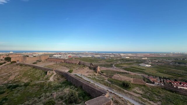 Sagunto provide a historic perspective of the Valencian Community landscape, extending towards the modern town and the distant Mediterranean Sea under a clear blue sky