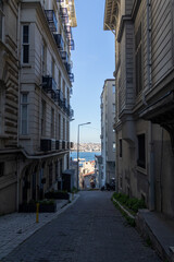 Fototapeta premium Istanbul Cihangir Narrow Cobblestone Street with Bosphorus View, Historic Apartment Buildings, Turkey