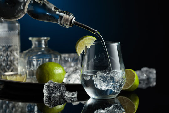 Gin is poured into a glass with ice.