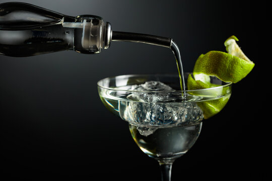 Vodka or gin is poured into a glass with ice.
