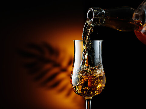 Rum being poured from a bottle into a glass.
