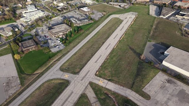 Cinematic aerial drone pull-back over the abandoned runways and decommissioned grounds of the former Buttonville Municipal Airport (CYKZ) in Markham, revealing the vast site slated for redevelopment