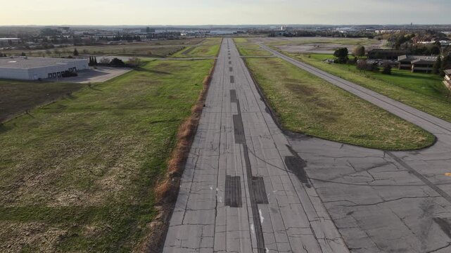 Aerial drone footage simulating a pilot's POV takeoff from the abandoned runway of the closed Buttonville Municipal Airport in Markham, ascending to reveal a wide shot of Highway 404 and GTA skyline