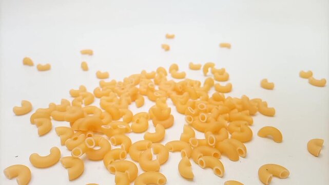 Elbow Macaroni Pasta Dropping on White Background, Uncooked Elbow Macaroni Pasta Ingredient