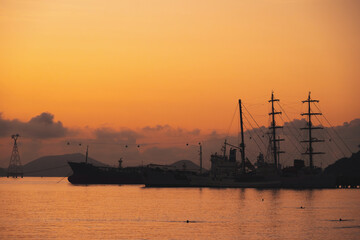 Naklejka premium Silhouettes of Vietnamese warships military ships in port at sea in the morning at dawn in harbor in Nha Trang in Vietnam