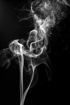 Abstract white smoke swirls and wisps isolated on black background
