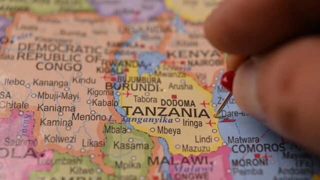 Close-Up World Map Shot Showing Red Pin Highlighting Tanzania Pointed by Hand 4K 60fps
