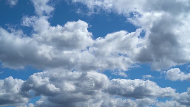White clouds freely drift across the open blue sky in clear weather.