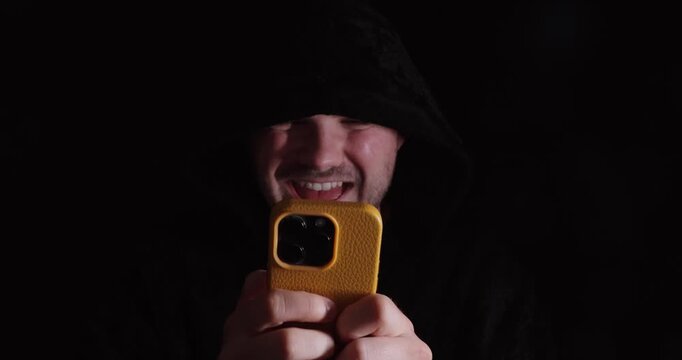 Man using a smartphone in a dark setting, symbolizing cyberbullying, online hate, and toxic social media behavior.