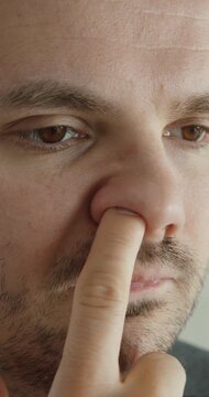 Close-up of a man picking his nose, representing hygiene issues, bad habits, and personal behavior.