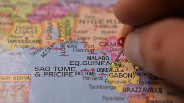Close-Up World Map Shot Featuring Red Pin Highlighting Equatorial Guinea Pointed by Hand 4K 60fps
