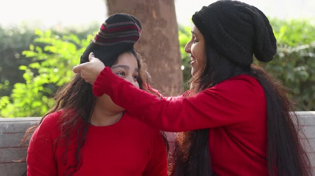 A caring Indian mother adjusting her daughter&rsquo;s cap in a peaceful outdoor park, capturing affection, family bonding, and simple daily life moments reflecting slum village poor india lifestyle